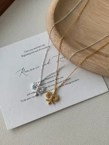 Detail of silver and gold fleur-de-lis necklaces with small sparkling diamonds