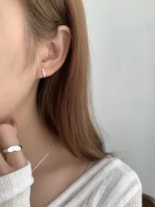 Primo piano di orecchini in argento S925 con zirconi indossati da una modella