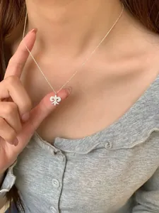 Macro shot of a S925 sterling silver fleur-de-lis necklace worn on a female model
