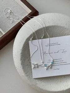 Detailed macro shot of S925 silver necklace with starfish shell charms and blue beads