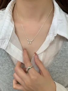 Detail of silver starfish and shell necklace with pearls worn on a stylish woman