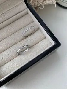 Detailed macro shot of S925 sterling silver couple rings with pavé diamonds and milgrain edges