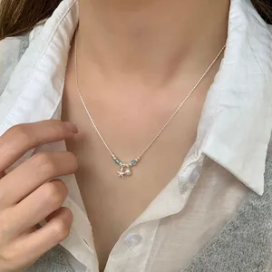 Silver S925 necklace with starfish, shell charms and blue beads on a female model