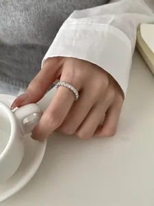Close-up of S925 sterling silver eternity ring with pavé diamonds on a hand