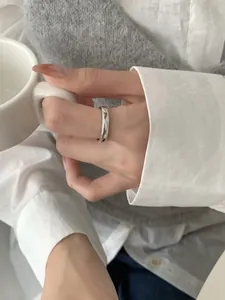 Detailed view of S925 sterling silver minimalist textured ring on finger with coffee cup