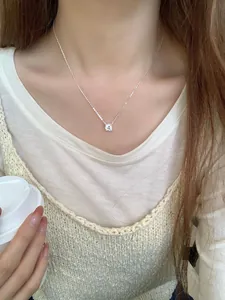Primer plano de un colgante solitario brillante en cadena de plata S925 en una modelo