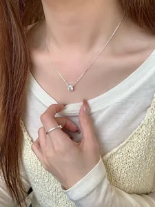Conjunto de collar y anillo minimalista de plata S925 usado por modelo para un look de lujo