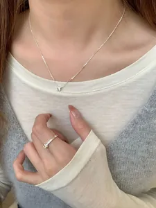 Detalle de collar S925 de plata con diamante y anillo en una modelo femenina
