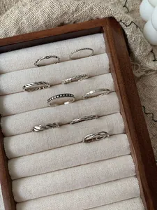 Gros plan de bagues vintage en argent sterling S925 sur un présentoir à bijoux en lin
