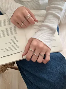 Gros plan de bagues empilables en argent massif S925 style vintage sur un livre