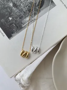 Détail des colliers en argent S925 doré et argenté avec pendentifs à vagues irrégulières