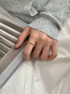 Minimalistische slanke vergulde ring aan vinger met elegante lifestyle achtergrond