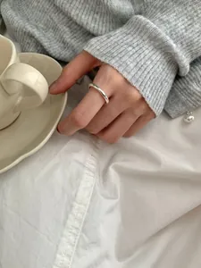 Detailopname van een minimalistische gepolijste S925 zilveren ring op vinger met zachte sfeer