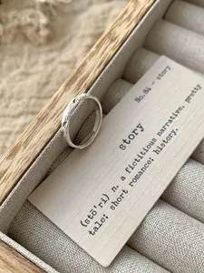 Close-up of a sparkling S925 silver ring with fine textures in a wooden jewelry box