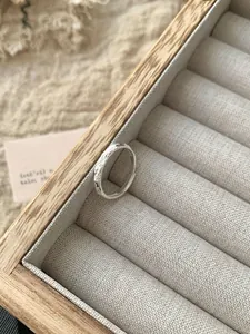 Macro shot of S925 sterling silver hammered texture open ring in a wooden box