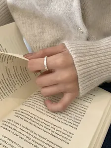 Detail of S925 sterling silver ring with hammer texture worn on finger by an antique book