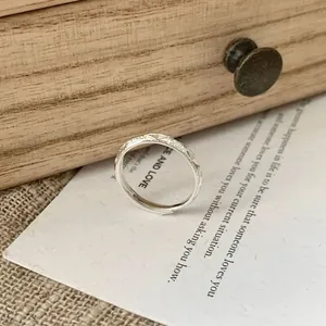 Minimalist S925 sterling silver open ring with geometric textured surface on a paper card
