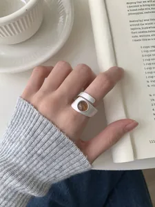 Détail d'une bague en argent brossé avec pierre marron portée par un mannequin