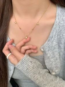 Gros plan du collier S925 étoile à huit branches dorée avec pendentif losange sur modèle