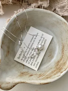 Detailopname van een S925 zilveren ketting op een rustiek keramisch bordje