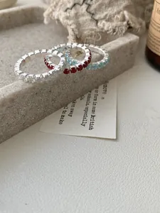 Détail de trois bagues empilables en argent S925 avec zircons blancs rouges et bleus