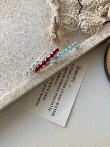 Détail macro de trois bagues en argent avec zircons carrés blancs, rouges et bleus