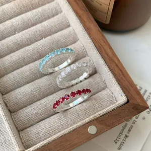 Trois bagues éternité en argent S925 avec zircons bleus, blancs et rouges en boîte bois