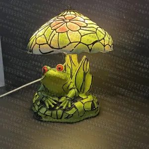 Detailed close-up of a green frog resin base and floral stained glass lamp shade