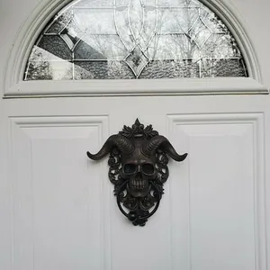 Detailed close-up of a bronze resin ram skull door knocker on a white wooden door