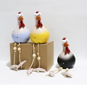 Detailed close-up of three resin chicken figurines with long rope legs in blue, yellow and black
