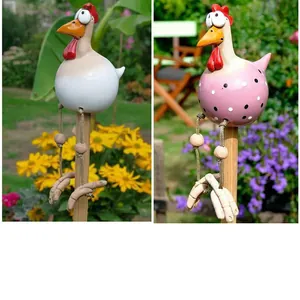 Detail of creative resin chicken garden stakes with long rope legs in a flower bed