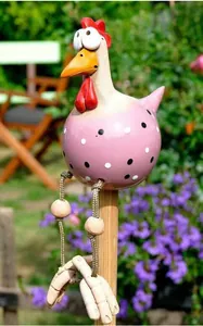 Detailed close-up of a pink resin garden chicken ornament with white polka dots on a wooden pole