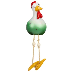 Detail of funny resin rooster ornament with big eyes, green gradient body and long rope legs