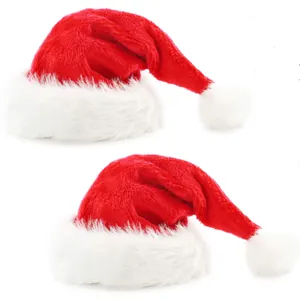 Close-up of two plush red and white Christmas hats with soft faux fur pompom details