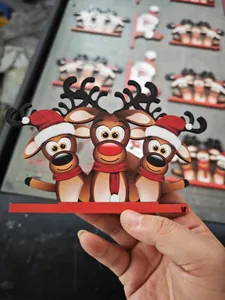 Detail of three wooden Christmas reindeer with red hats and scarves on a support base