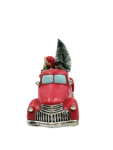 Detail of red vintage resin truck ornament carrying a snowy Christmas tree and elf figure