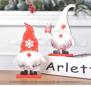 Detail von zwei hölzernen Weihnachtswichteln mit roten Mützen und Plüschbärten