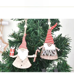 Détail de suspensions gnomes de Noël en bois avec lettrage XMAS sur sapin de Noël