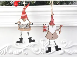 Détail de gnomes de Noël en bois avec jambes à ressort sur une cheminée blanche festive