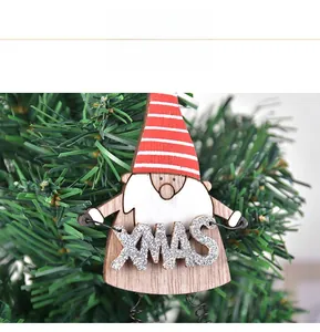 Détail d'un gnome en bois avec inscription XMAS sur une branche de sapin festive