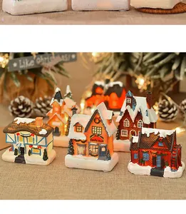 Close-up of lighted Christmas resin miniature houses featuring a Candy Shop and snowy roof