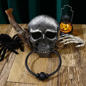 Detailed view of a vintage silver skull door knocker with a black ring for Halloween decor