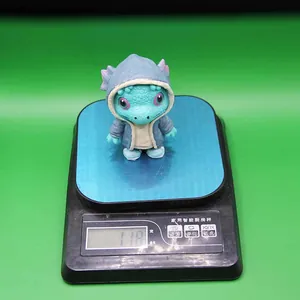 Close-up of cute blue dinosaur resin figurine weighing 118g on a digital kitchen scale