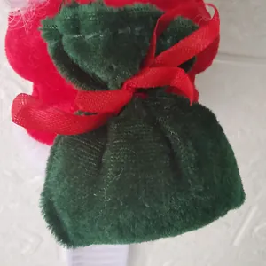 Detailed close-up of dark green velvet pouch with a red ribbon bow for Christmas decor