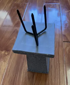 Close-up of black metal garden decorative stake with three-prong design on gray base