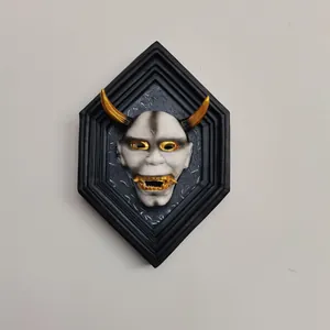 Detail of Hannya mask wall art with golden horns on black hexagonal frame base