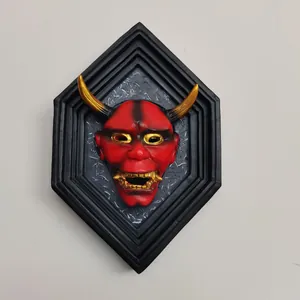 Detailed wall-mounted red resin Hannya mask in a black hexagonal frame with gold accents