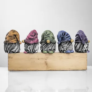 Macro detail of five resin garden gnomes with textured hats and gray beards for outdoor decor