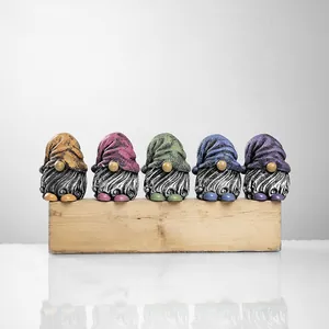 Detailed view of 5 colorful resin garden gnomes with knitted hat textures on wood