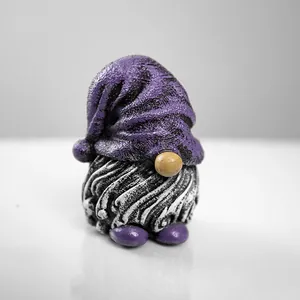 Macro shot of handcrafted gnome garden resin ornament with purple hat and spiral textures